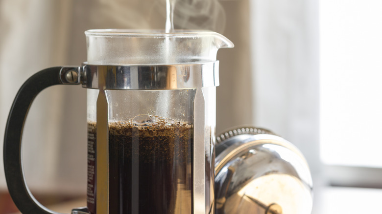 Person pouring water into French press