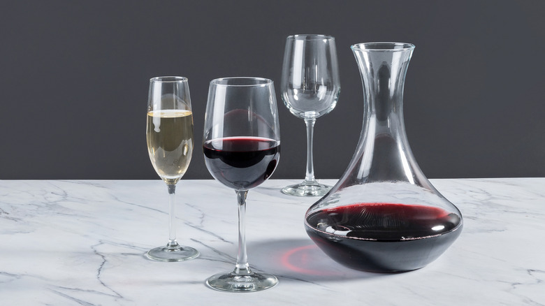 Decanter with red wine and glasses with white and red wines.