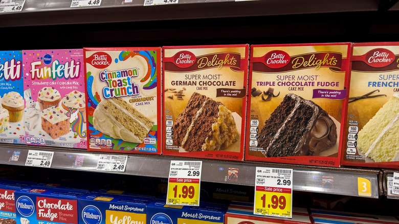 Boxed cake mixes on grocery shelves.