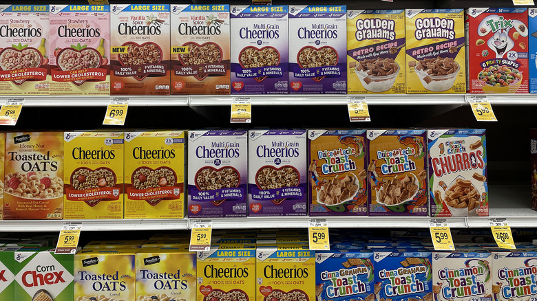 Assorted cereals on store shelf with price tags