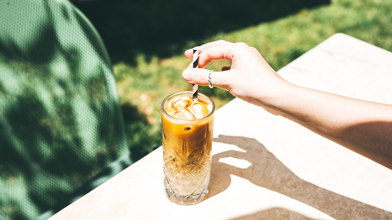 Person stirred an iced coffee with a paper straw