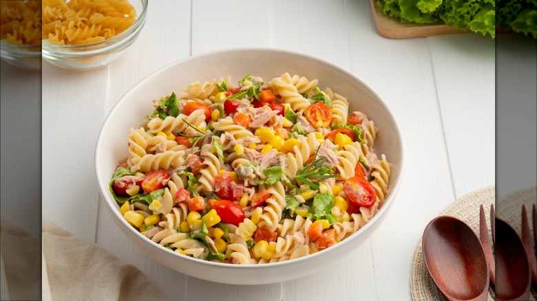 Pasta salad and tomatoes on blue background