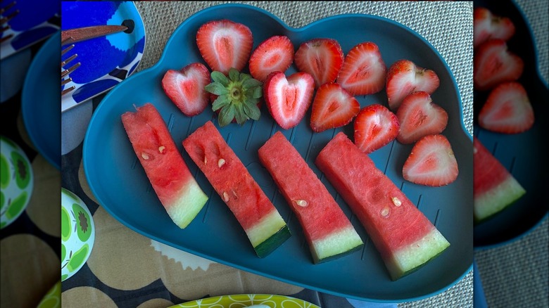 Watermelon sticks and cut strawberries on a plate
