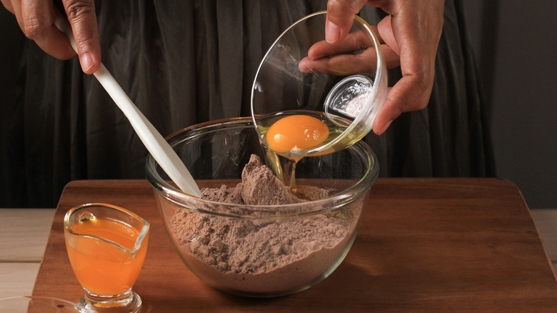 adding egg to brownie mix