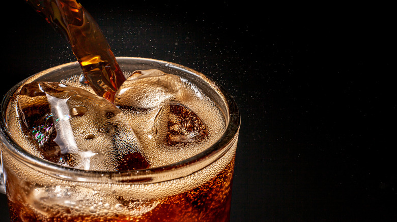 Soda poured into a glass with ice