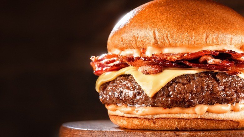 up close view of burger topped with cheese and bacon