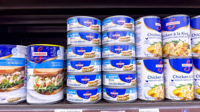 Cans of chicken on grocery shelf