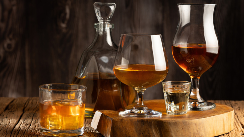 Variety of spirits in different styles of drinking glasses.