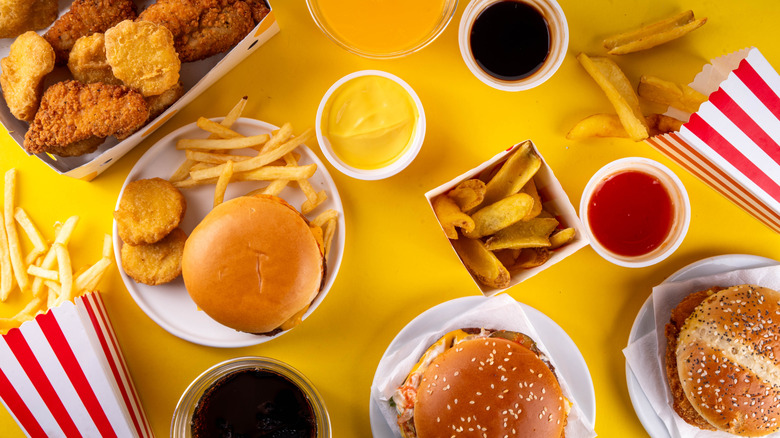 Array of fast food on yellow surface overhead view