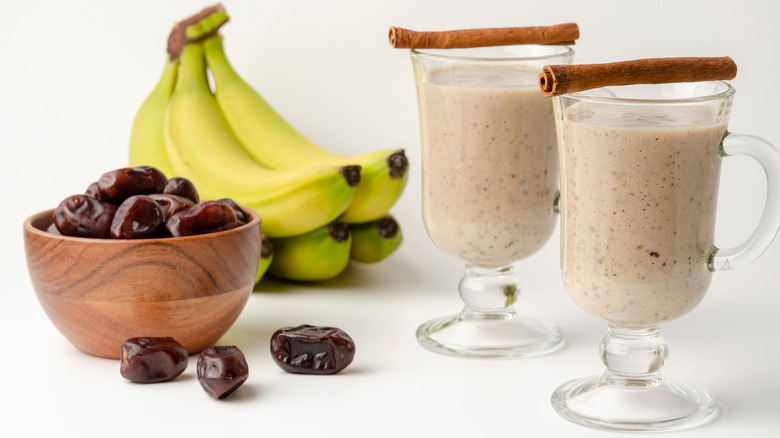 Date and banana shake with banana bunch and bowl of dates