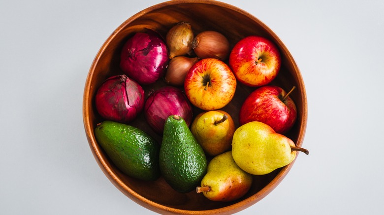 Bowl with avocados, pears, apples, onions, and shallots