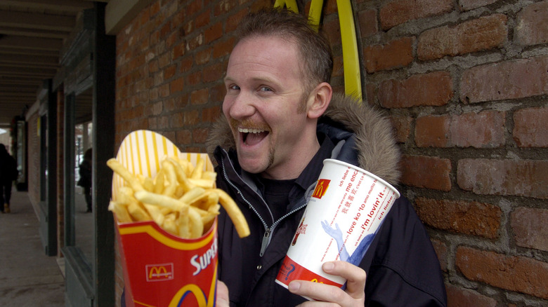 Morgan Spurlock holding McDonald's fries and soda