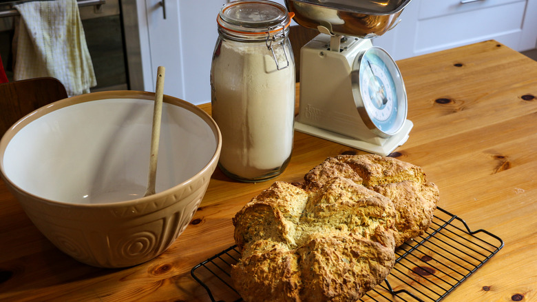 Soda bread with flour, mixing bowl and a weighing scale