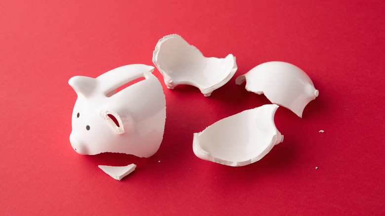 Broken piggy bank on red background