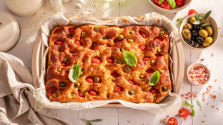 Focaccia in pan with tomatoes and olives