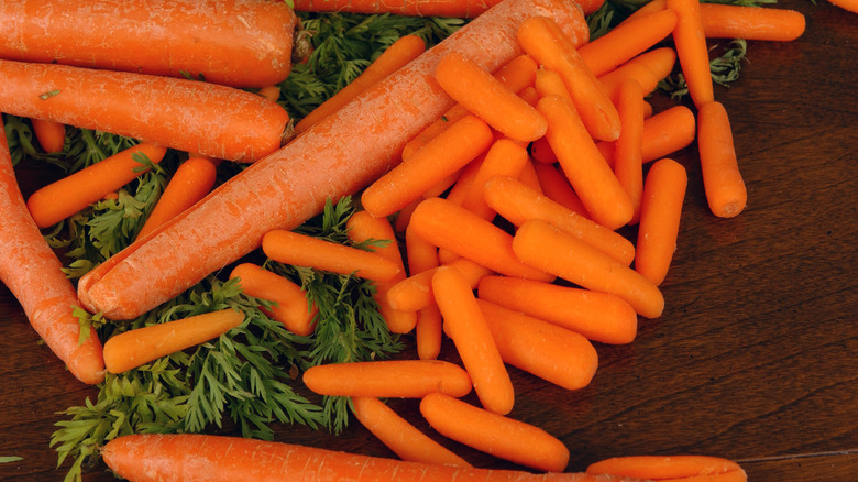 a close-up of baby carrots on a bed of carrot greens