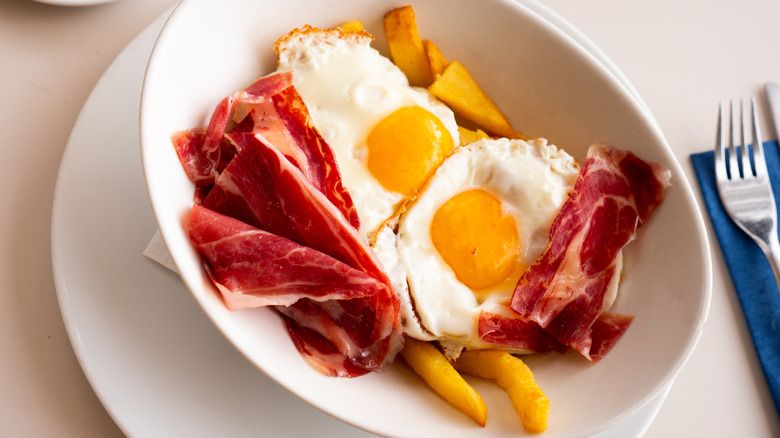 Traditional Spanish fried eggs served with bacon.