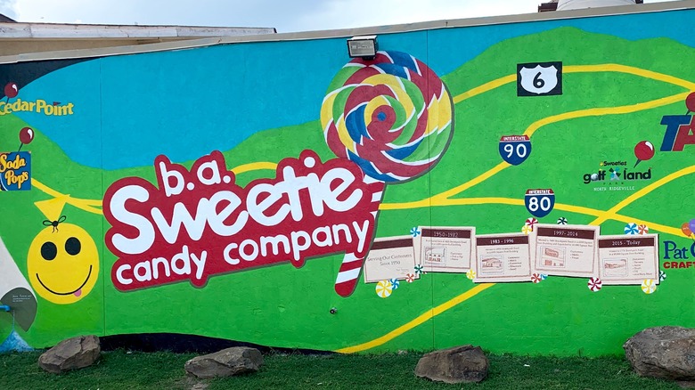 b.a. Sweeties Candy Company logo on green and blue wall with lollipop