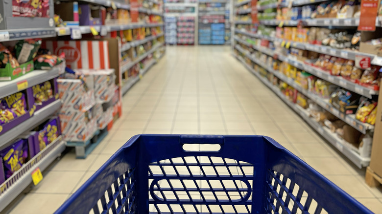 An empty shopping cart is pointed down an aisle