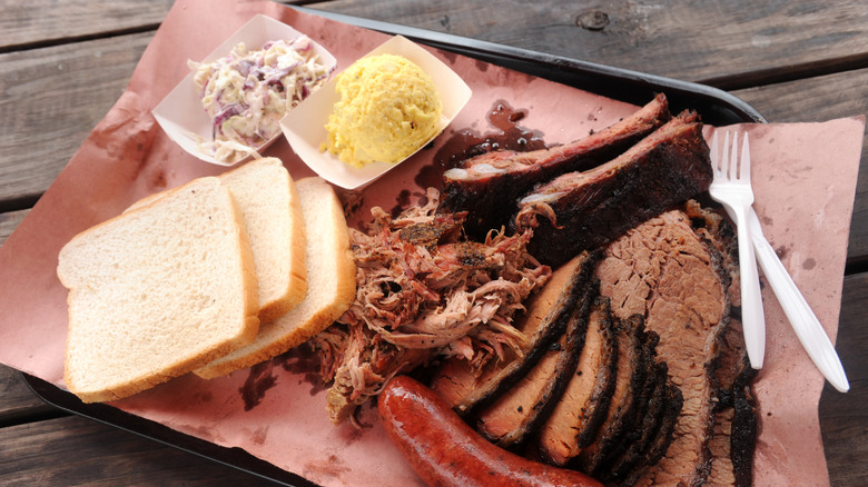 Barbecue plate with meats, sides, and slices of white bread