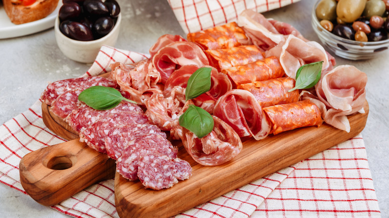 a charcuterie board of various meats and olives