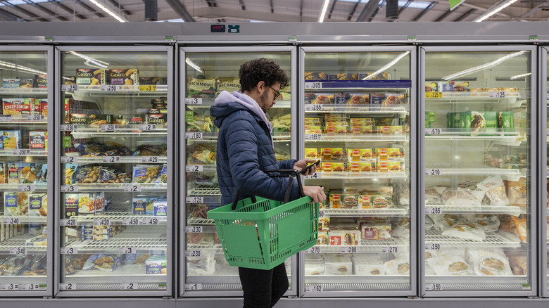 A man in a grocer's freezer aisle