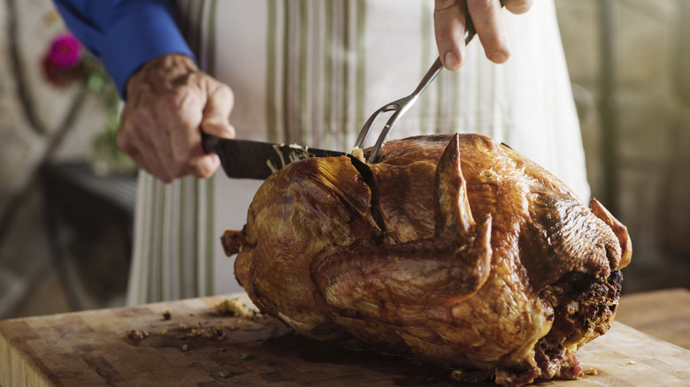 person carving a turkey