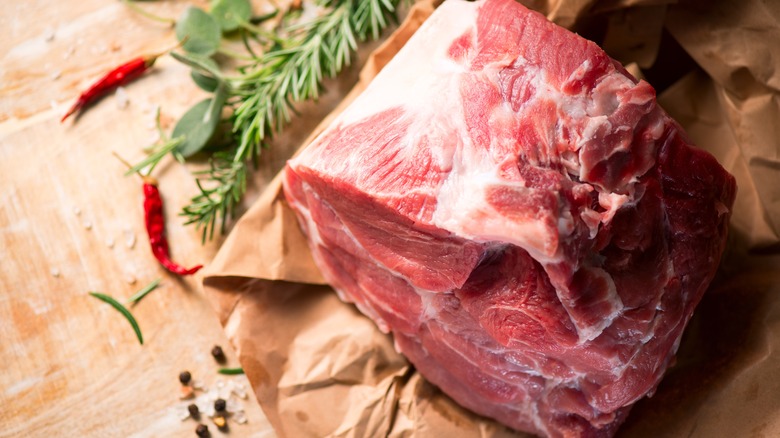 A raw pork shoulder roast, perfect for braising