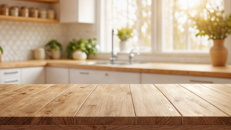 Kitchen interior, wooden surface in closeup in foreground