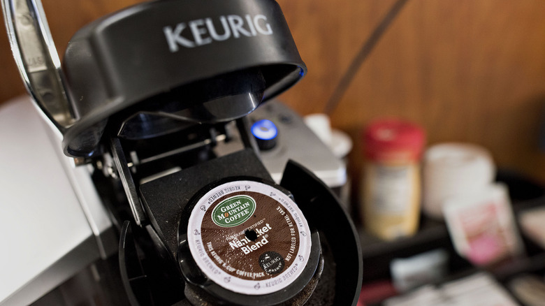 an open Keurig, showing a punctured coffee pod