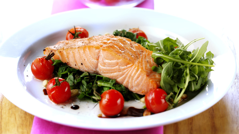 Salmon served with arugula and tomatoes