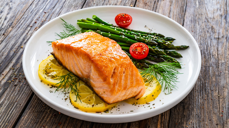 Salmon served with asparagus, lemon, dill, and tomatoes