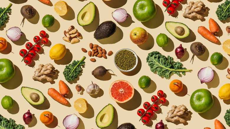 Wide variety of fruits and vegetables on beige background.