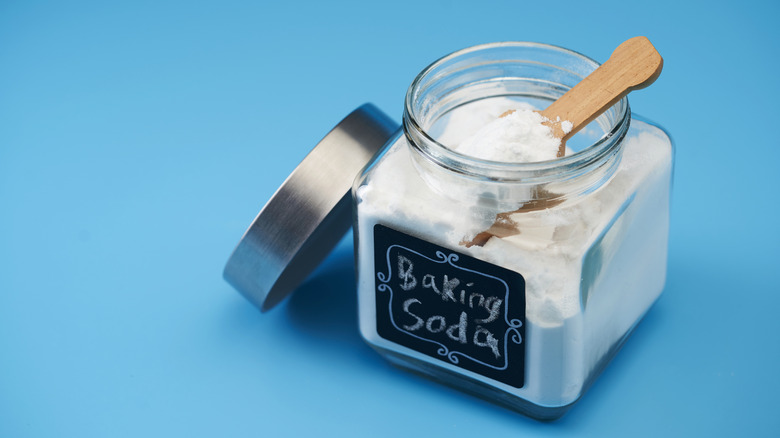 Baking soda in labeled jar on blue background.