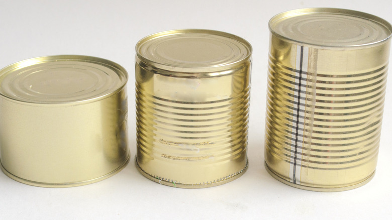 Three aluminum cans in height order with their labels removed.