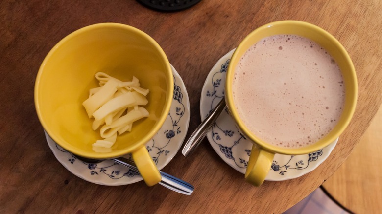 Hot chocolate in cup and cheese in cup