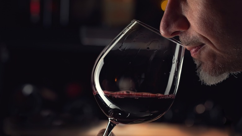 Person smelling wine from glass