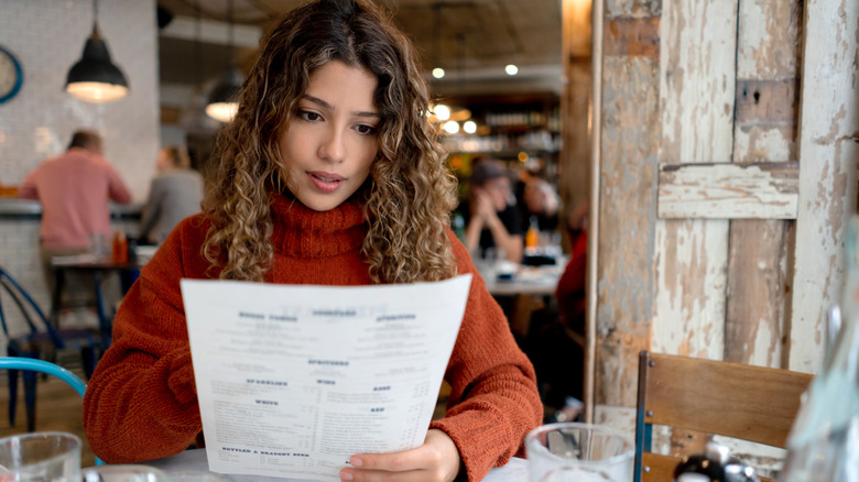 Woman reading a restaurant menu 