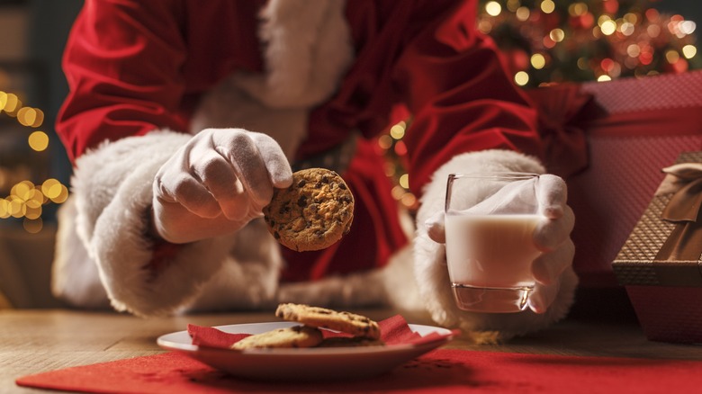 Santa grabbing a cookie and milk