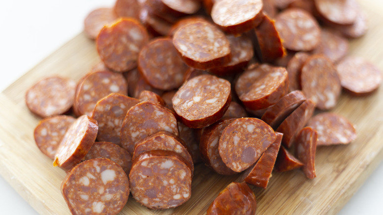 Sliced chorizo on wooden cutting board