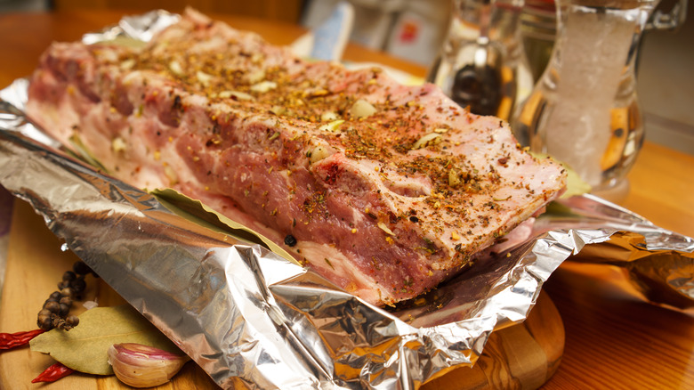 Raw ribs seasoned and sitting in foil