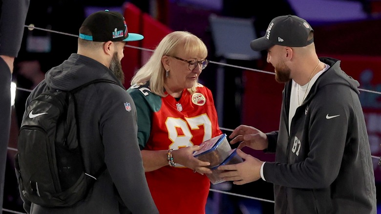 Donna Kelce giving Tupperware containers of cookies to her sons Jason and Travis before Super Bowl LVII