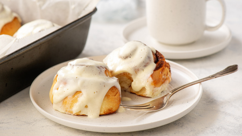 cutting cinnamon roll with fork