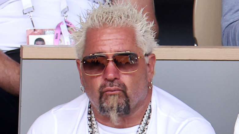 A close-up of a pensive Guy Fieri