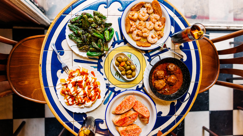 Spanish tapas including olives, patatas bravas, and shrimp