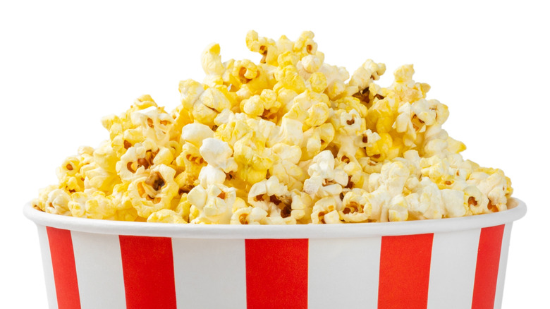 Red and white tub of popcorn with a white background.