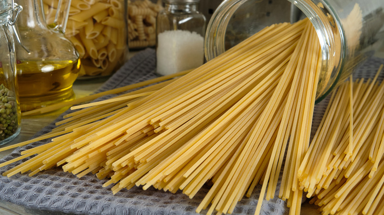 Dried pasta on table with glass jar