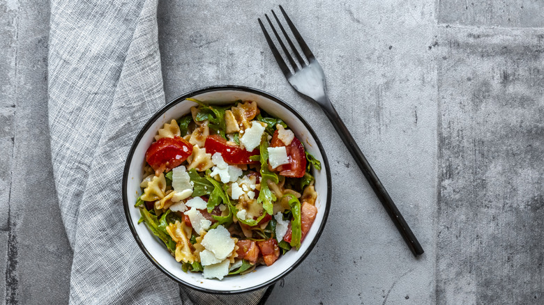 A bowl of pasta salad on a gray background