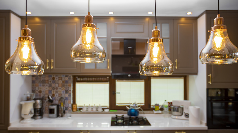 Four hanging lights in a kitchen.