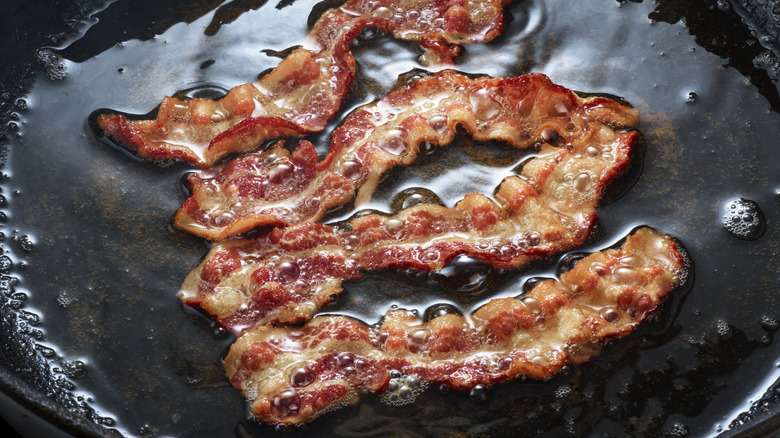 bacon being cooked in a pan